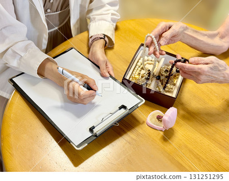 一位老婦人手裡拿著一盒配件，手上填寫著表格 131251295