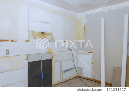 Kitchen undergoing renovation bare walls, missing tiles, unfinished surfaces, ready for updates. Kitchen undergoing renovation bare walls, missing tiles, unfinished surfaces, ready for updates. 131251527