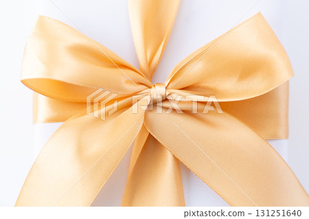 White gift with gold ribbon 131251640