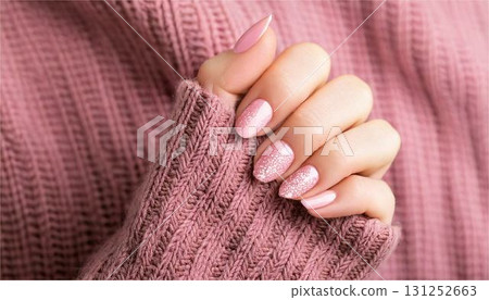 Winter sparkly nails and knitwear. AI-generated image of pink glitter nails and a warm-looking sweater. Beauty Winter 131252663