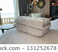 Neatly folded white towels stacked on a soft bed in a hotel room 131252678