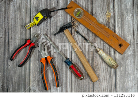 Assorted work tools lying on rustic wooden table 131253116