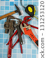 Essential plumbing tools lying on blue bathroom tiles ready for home improvement 131253120