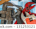 Adjustable wrenches and pipe wrench laying on blue tiles 131253121