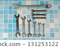 Set of wrenches lying on blue tiles, showing plumbing and maintenance concept 131253122