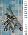 Wrenches and spanners lying on blue tiles creating plumbing concept 131253124