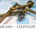 Screws, bolts, nuts and washers lying on blue tiles 131253126