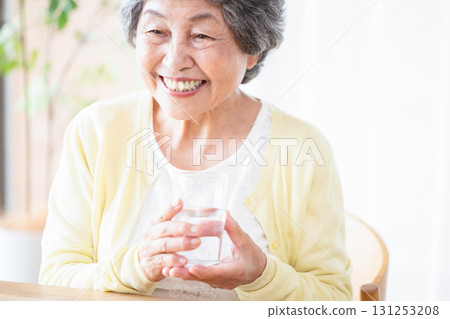 A woman holding a glass of water 131253208