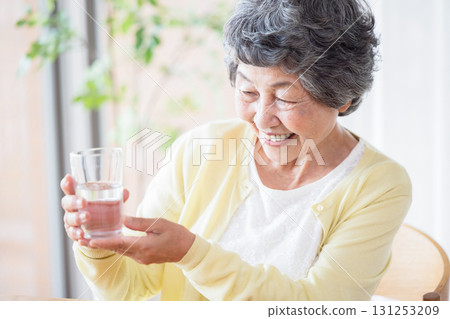 A woman holding a glass of water A woman holding a glass of water 131253209