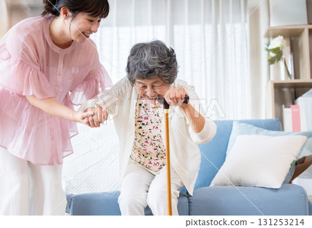 A young woman assisting a senior woman using a cane A young woman assisting a senior woman using a cane 131253214