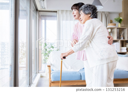 一名年輕女子協助一名使用拐杖的老年婦女 131253216