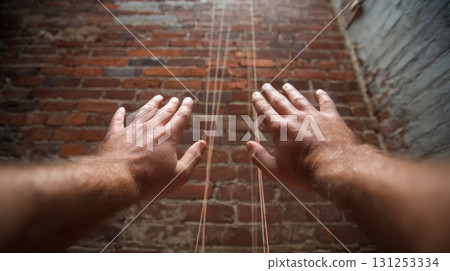 First-Person View of Hands Checking Plumb with Level Tool on Brick Wall 131253334