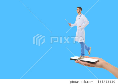 Doctor holds a pointer while standing on a smartphone in hand 131253339