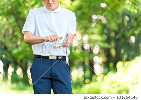 Male golfer wearing golf gloves 131254140