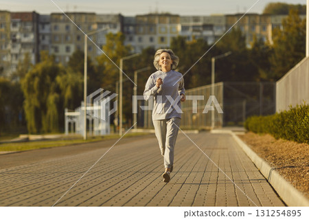 Happy, fit, smiling, senior woman having an active running workout in the city park Happy, fit, smiling, senior woman having an active running workout in the city park 131254895