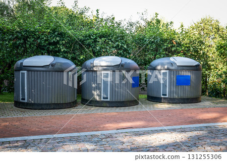 Three Modern Urban Waste Bins on Brick Pavement 131255306