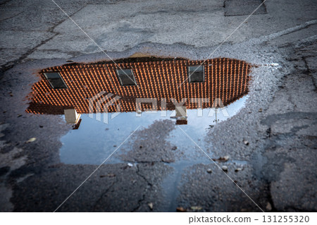 Red Roof House Reflection in Rainwater Puddle Red Roof House Reflection in Rainwater Puddle 131255320