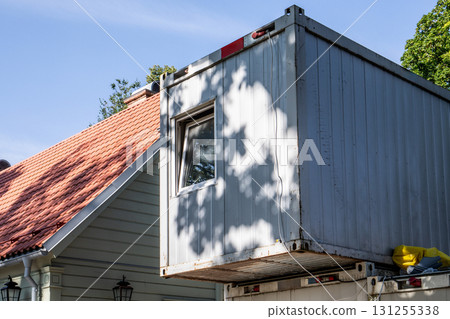 Shipping Container Attached to Traditional Residential Building Wall Shipping Container Attached to Traditional Residential Building Wall 131255338