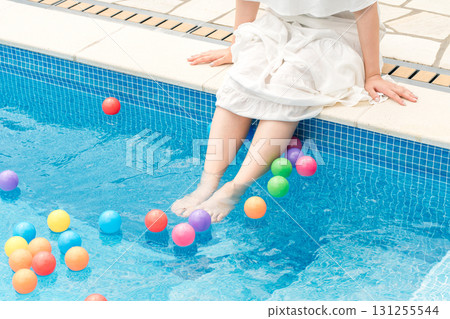 旅行中，一位女士在度假酒店泳池邊玩耍的腳 131255544