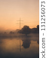 Powerline on hazy morning with reflection in lake 131256073