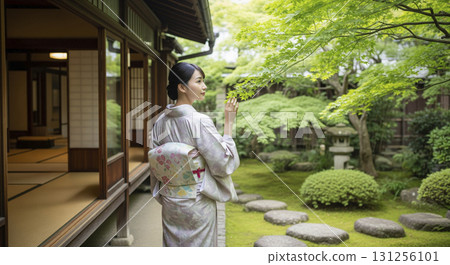 一位身穿和服的日本女子從陽台望向花園，綠色的楓葉 131256101