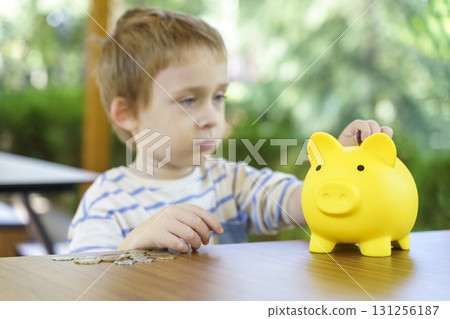 Boy Saving Money in Piggy Bank. Childhood Finance Education 131256187