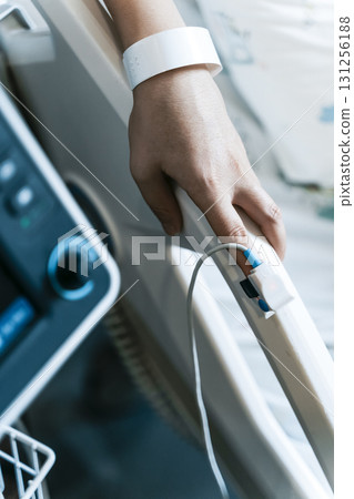 Patient's Finger Connected to Pulse Oximeter on Medical Monitor 131256188