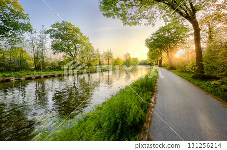 A Beautiful and Serene Canal Pathway Surrounded by Lush Greenary During a Stunning Sunset Glow A Beautiful and Serene Canal Pathway Surrounded by Lush Greenary During a Stunning Sunset Glow 131256214