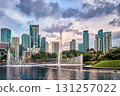 Panoramic view of Kuala Lumpur city center, Malaysia, with contemporary skyscrapers, KLCC park lake, fountains, lush greenery, dramatic evening sky, architectural landmarks. Reflection cityscape in 131257022