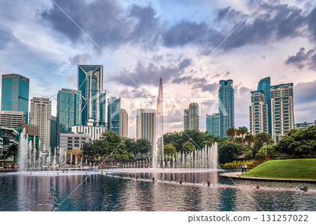Panoramic view of Kuala Lumpur city center, Malaysia, with contemporary skyscrapers, KLCC park lake, fountains, lush greenery, dramatic evening sky, architectural landmarks. Reflection cityscape in 131257022