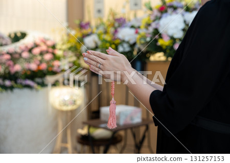 一名年輕女子在殯儀館祈禱的手 一名年輕女子在殯儀館祈禱的手 131257153