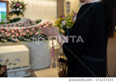 Hands of a young woman praying at a funeral home Hands of a young woman praying at a funeral home 131257155