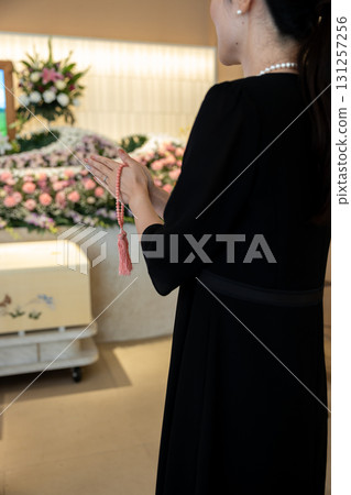 一名年輕女子在殯儀館祈禱 131257256