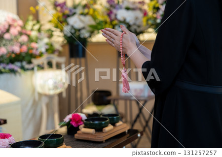 一名年輕女子在殯儀館祈禱 一名年輕女子在殯儀館祈禱 131257257