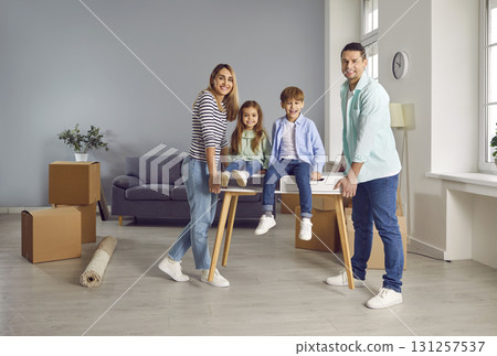 Happy parents having fun with children in new apartment Happy parents having fun with children in new apartment 131257537