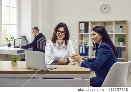 Happy young woman consulting at bank manager, financial advisor or loan broker Happy young woman consulting at bank manager, financial advisor or loan broker 131257538
