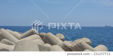 Concrete Tetrapod Breakwater and Ship on Blue Sea, Cyprus Concrete Tetrapod Breakwater and Ship on Blue Sea, Cyprus 131257713
