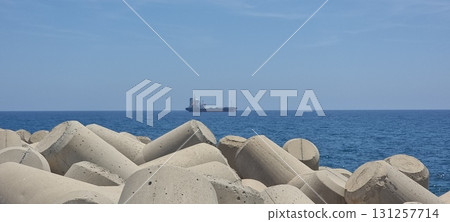Concrete Tetrapod Breakwater and Ship on Blue Sea, Cyprus Concrete Tetrapod Breakwater and Ship on Blue Sea, Cyprus 131257714