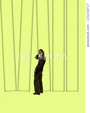 Digital artwork. Young man in brown sweater and glasses on minimal lime green background with tall abstract shapes Digital artwork. Young man in brown sweater and glasses on minimal lime green background with tall abstract shapes 131258717