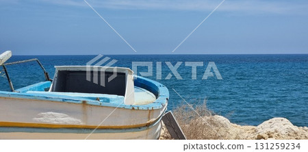 Old Fishing Boat on Rocky Mediterranean Coast, Cyprus Old Fishing Boat on Rocky Mediterranean Coast, Cyprus 131259234