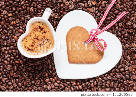 Heart shaped cup and cookie on coffee beans background 131260593