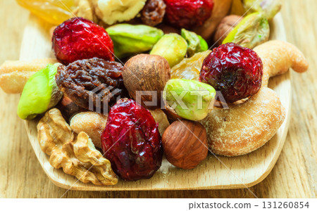 Varieties of dried fruits and nuts on wooden spoon. 131260854
