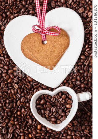 Heart shaped cup and cookie on coffee beans background Heart shaped cup and cookie on coffee beans background 131260870