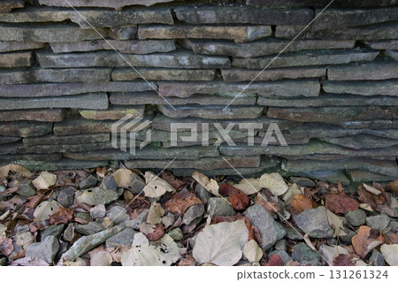 Stacked stone wall and fallen leaves horizontal 131261324