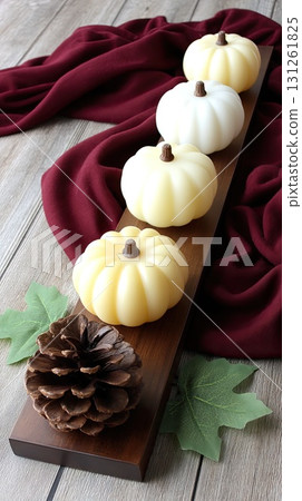 Elegant display of candles with colorful pumpkins and pinecones adds a cozy touch to the autumn season in a bright setting 131261825