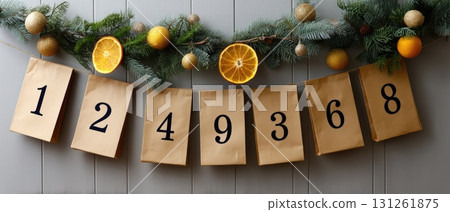 Gift bags are carefully displayed on a string, surrounded by fresh oranges, herbs, and natural elements on a wooden tabletop 131261875