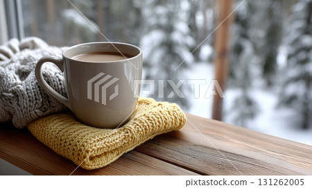 A cozy setting features a warm mug of coffee resting on a knitted fabric, with snow-covered trees visible through the window 131262005