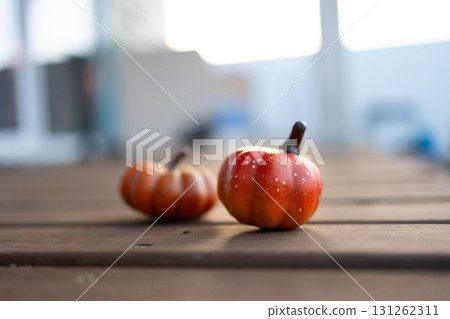 Two Small Orange Pumpkins Decorate a Brown Wooden Table Top 131262311