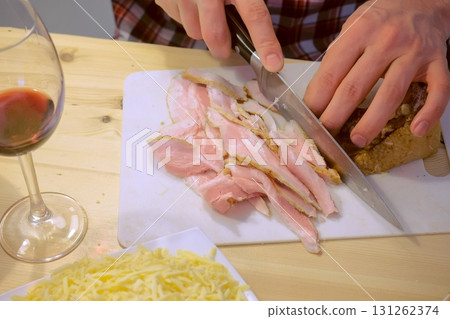 Man cuts smoked brisket, hands close-up. Prepares the ingredients for pizza. Man cuts smoked brisket, hands close-up. Prepares the ingredients for pizza. 131262374