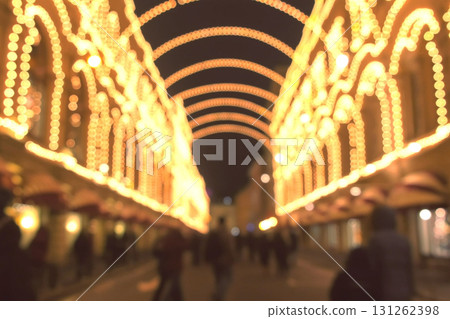 Beautiful building with arches in Christmas lights at night. People walking on the street in city. Blur. Beautiful building with arches in Christmas lights at night. People walking on the street in city. Blur. 131262398